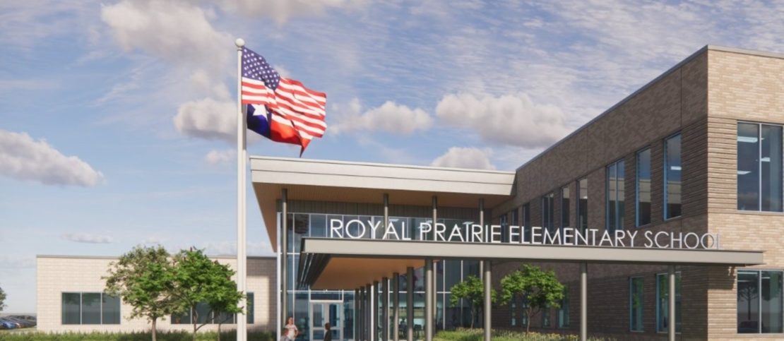 Exterior view of Royal Prairie Elementary School, featuring a modern building, glass entrance, and flagpole with the American and Texas flags.